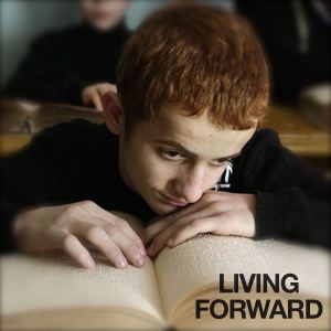 Be Informed_Accessible to All_Living Forward_Blind boy with red hair reading a braille book at school desk