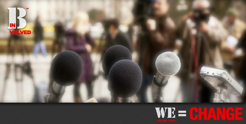 Be Informed_Recent Press_We Plus You Equals Change_photo of microphones on podium looking out into audience of members from the mainstream media and cameras