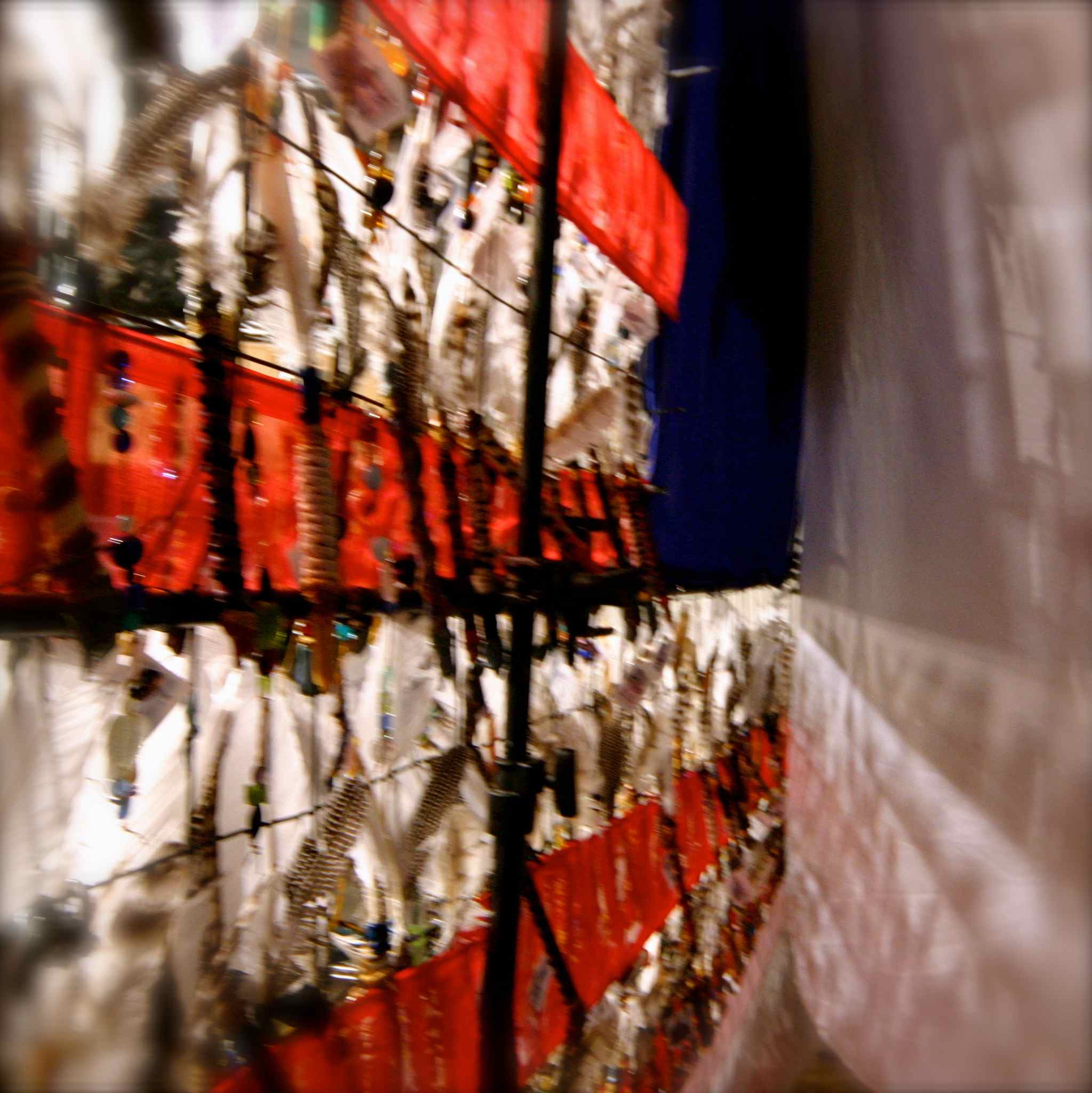 Be Involved_Story Flag Exhibit_photo of story flag peering between the layers from the side between the story sticks, and the 12 foot by 20 foot white silk that backdrops the story flag.